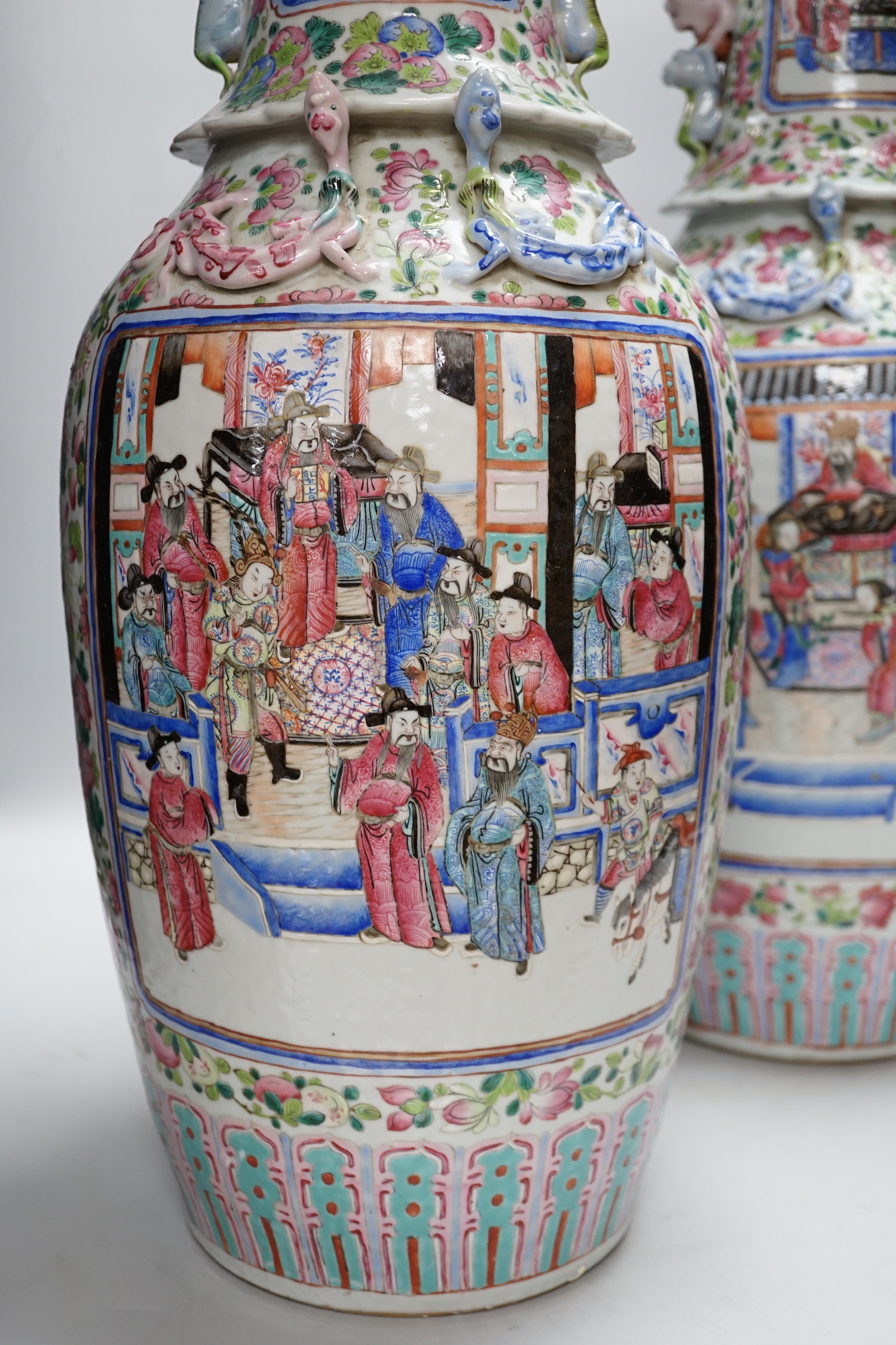 A pair of large Chinese porcelain famille rose vases, 19th century, decorated with court scenes and flowers, 61cm high